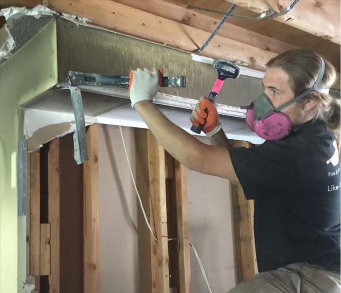 SERVPRO Technician with Hammer doing Demolition